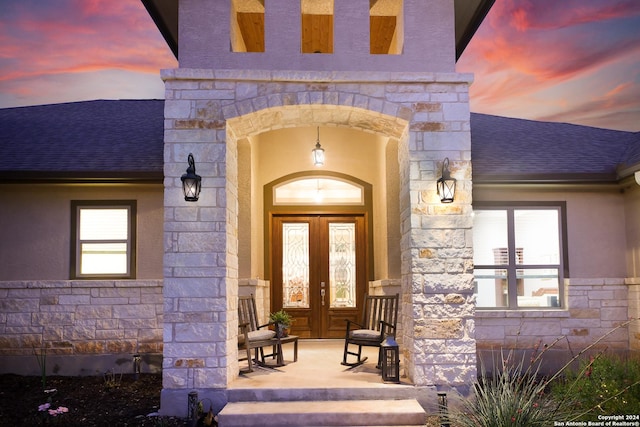 exterior entry at dusk featuring french doors