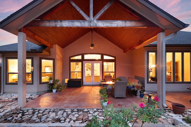 patio terrace at dusk featuring ceiling fan and french doors