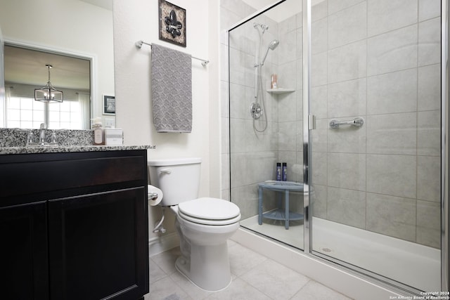 bathroom with tile patterned floors, vanity, toilet, and an enclosed shower