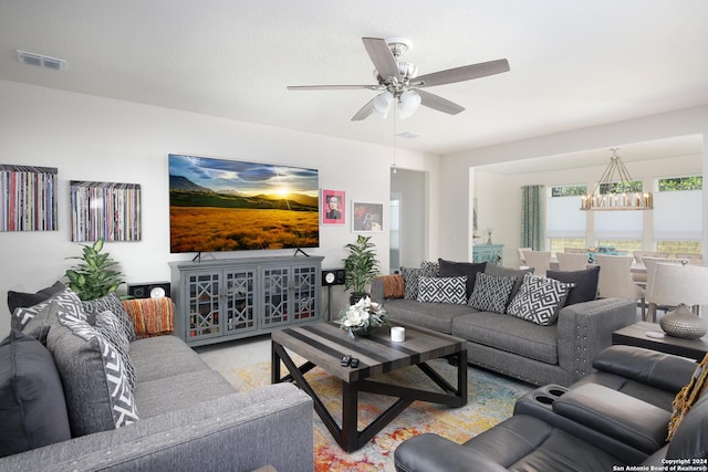 living room featuring ceiling fan with notable chandelier