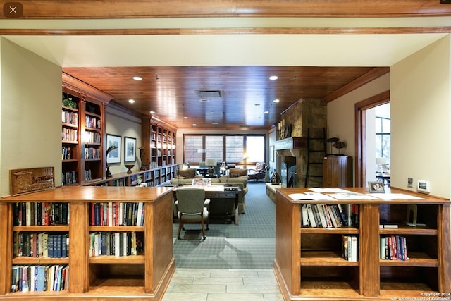 living room featuring a stone fireplace and wood ceiling