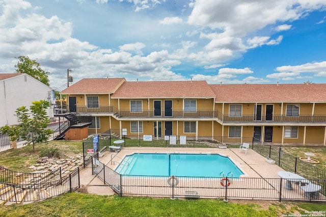 view of pool featuring central AC unit, a patio area, and a yard