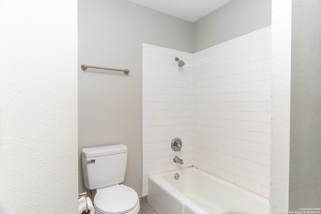 bathroom featuring toilet and tiled shower / bath