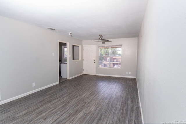 empty room with ceiling fan and dark wood-type flooring