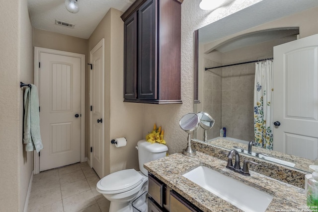 bathroom with toilet, a shower with shower curtain, tile patterned floors, a textured ceiling, and vanity