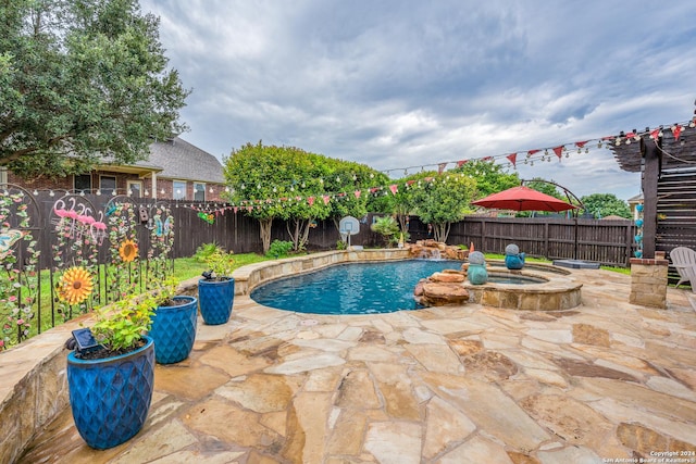 view of pool with a patio area and an in ground hot tub