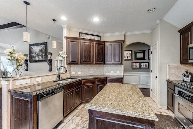 kitchen with sink, dark brown cabinetry, appliances with stainless steel finishes, and kitchen peninsula