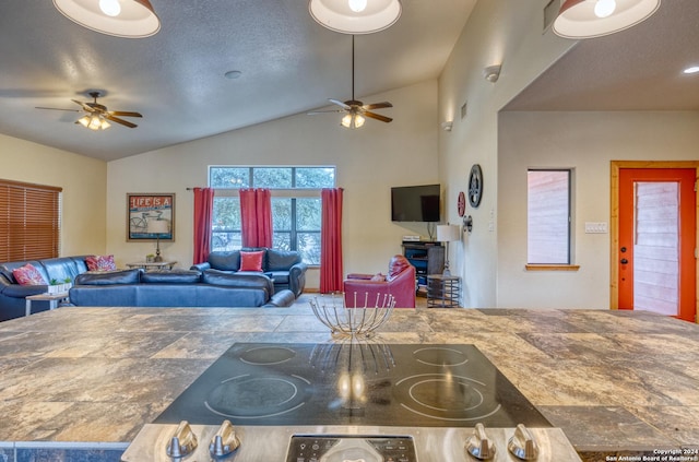 kitchen featuring ceiling fan, cooktop, a textured ceiling, and vaulted ceiling