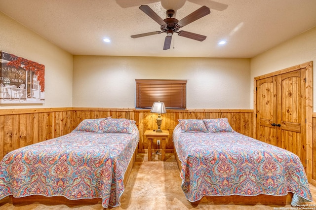 bedroom with a textured ceiling, ceiling fan, and light carpet