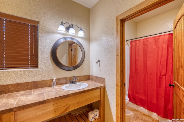 bathroom featuring toilet, walk in shower, and vanity