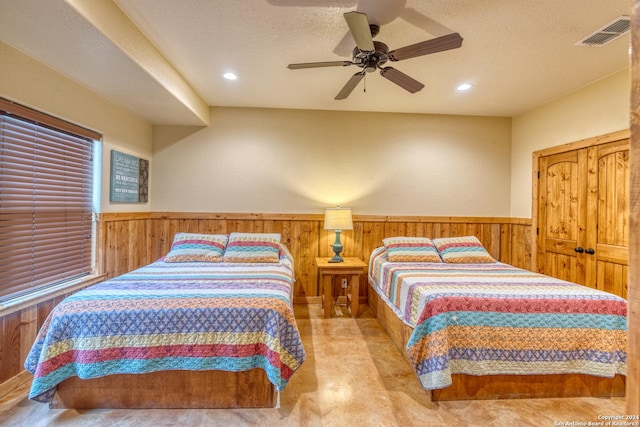 carpeted bedroom with ceiling fan and a textured ceiling