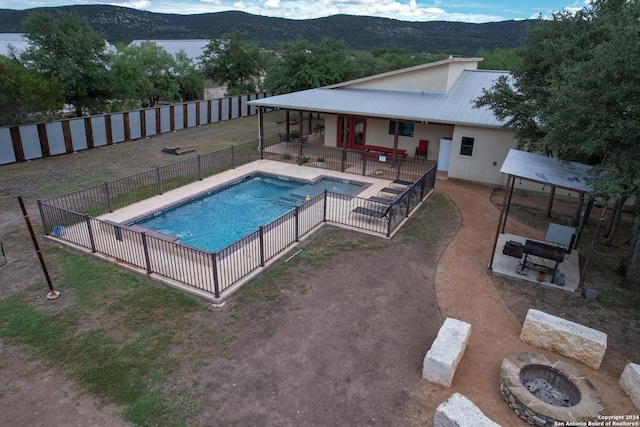 view of pool featuring a patio, a mountain view, and a fire pit