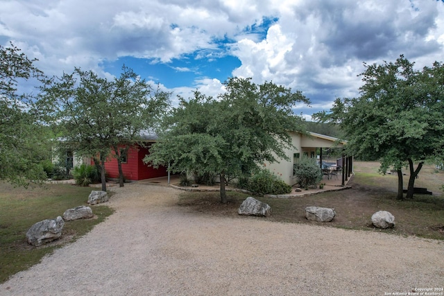 view of property hidden behind natural elements with covered porch