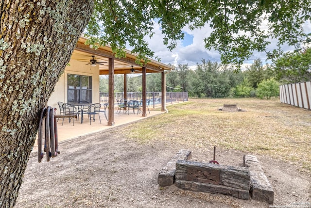 view of yard with ceiling fan, a patio area, and a fire pit