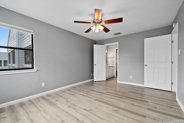 unfurnished bedroom with ceiling fan, ensuite bath, and light wood-type flooring