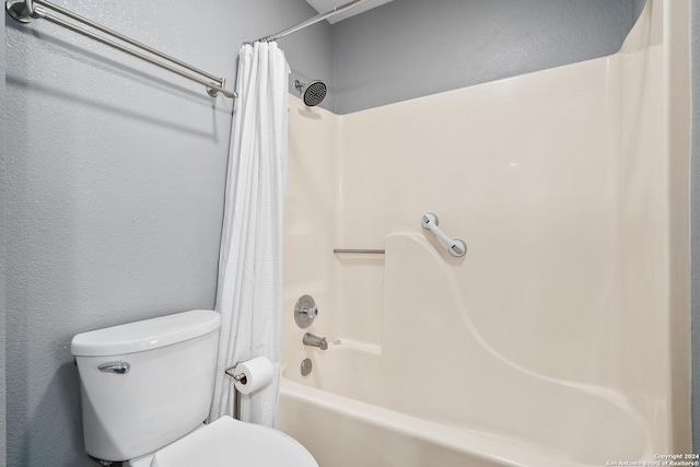 bathroom featuring toilet and shower / bath combo with shower curtain