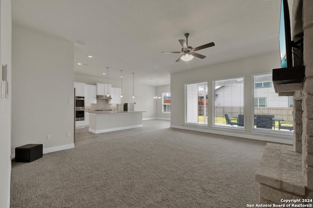 unfurnished living room featuring ceiling fan and light colored carpet