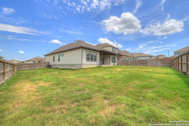 rear view of property featuring a lawn