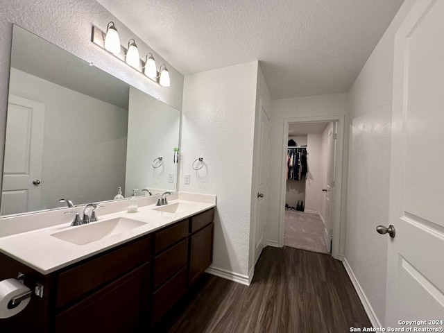 bathroom featuring a textured ceiling, wood-type flooring, and vanity