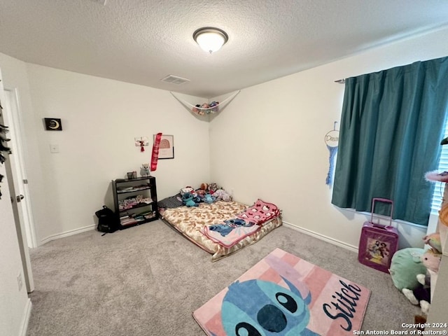 bedroom with a textured ceiling and carpet