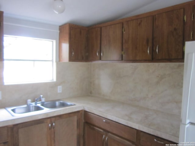 kitchen featuring brown cabinets, light countertops, and a sink