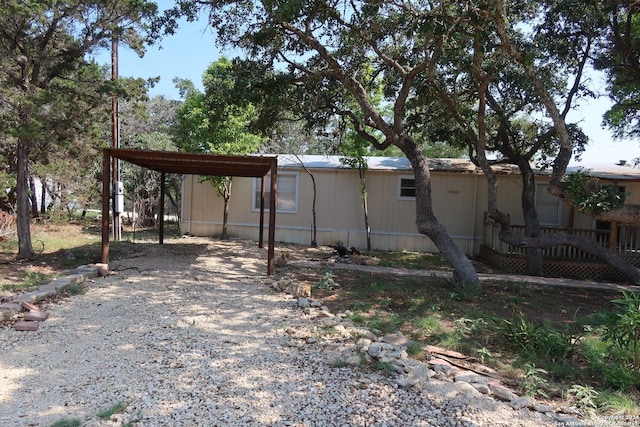 view of yard with a carport and gravel driveway