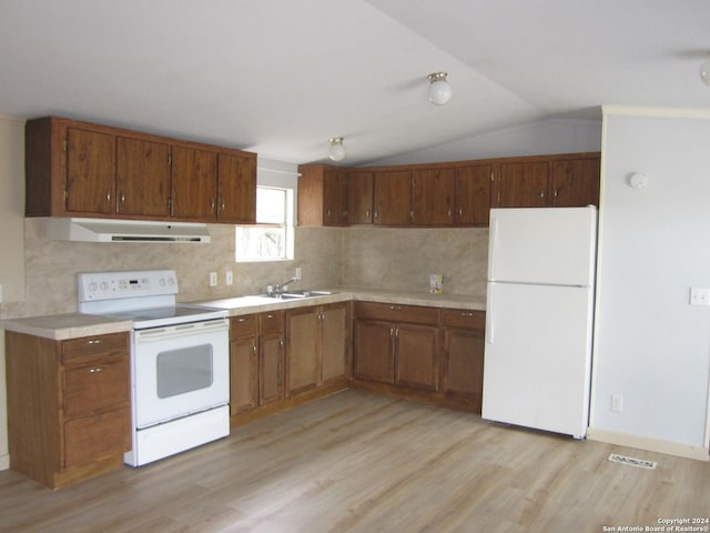 kitchen featuring under cabinet range hood, white appliances, a sink, light wood-style floors, and light countertops