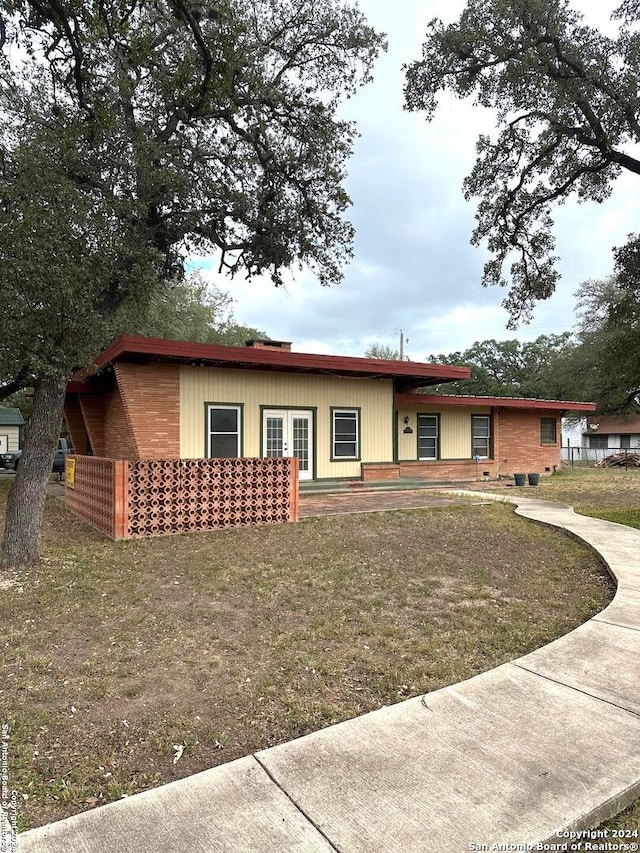 view of front facade with french doors and a front lawn