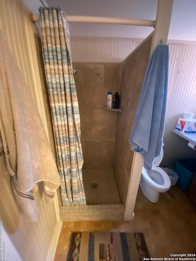 bathroom featuring a shower with curtain and toilet