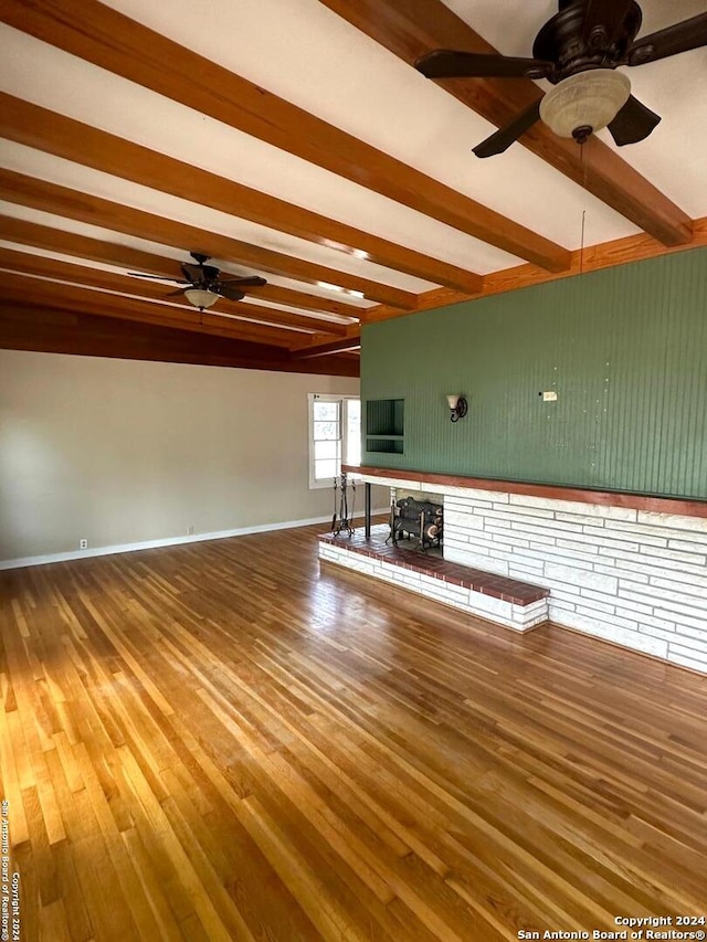 unfurnished living room with hardwood / wood-style flooring, ceiling fan, and beam ceiling