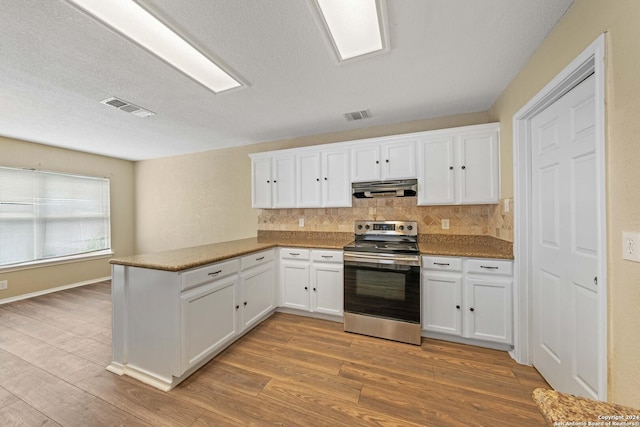 kitchen featuring stainless steel range with electric cooktop, white cabinetry, kitchen peninsula, tasteful backsplash, and light wood-type flooring