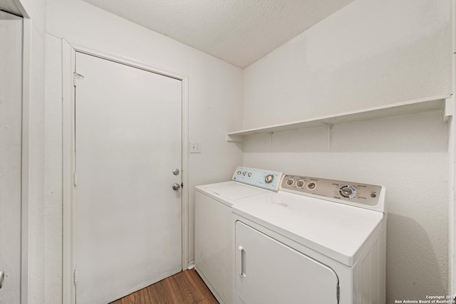 laundry area featuring dark wood-type flooring, a textured ceiling, and independent washer and dryer