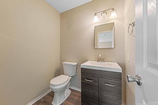 bathroom with hardwood / wood-style floors, toilet, and vanity