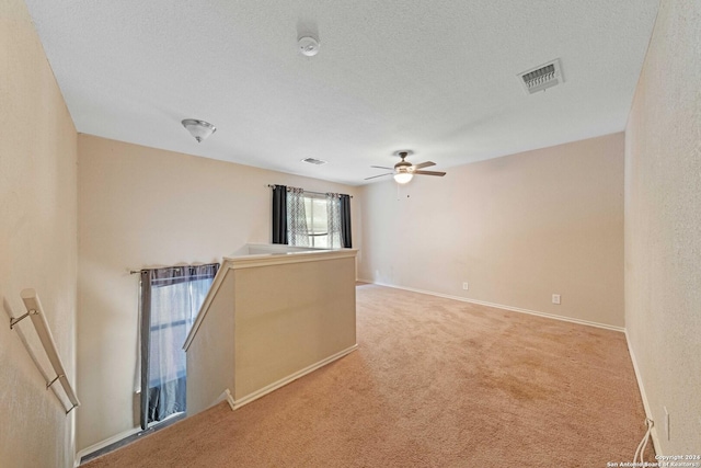 empty room with carpet floors, a textured ceiling, and ceiling fan