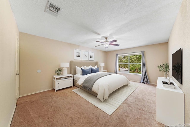 carpeted bedroom featuring a textured ceiling and ceiling fan