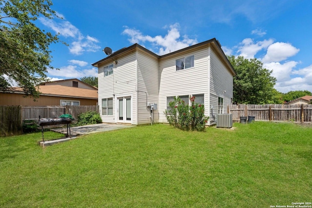 rear view of property featuring central AC, a lawn, and a patio