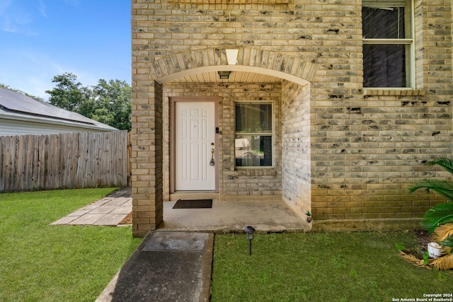 entrance to property featuring a lawn