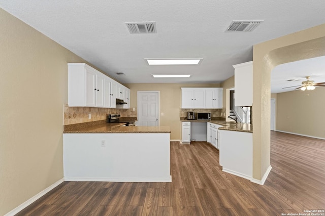 kitchen featuring stainless steel range with electric cooktop, white cabinetry, dark hardwood / wood-style flooring, kitchen peninsula, and ceiling fan