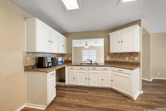 kitchen featuring ceiling fan, decorative backsplash, sink, white cabinets, and dark hardwood / wood-style flooring