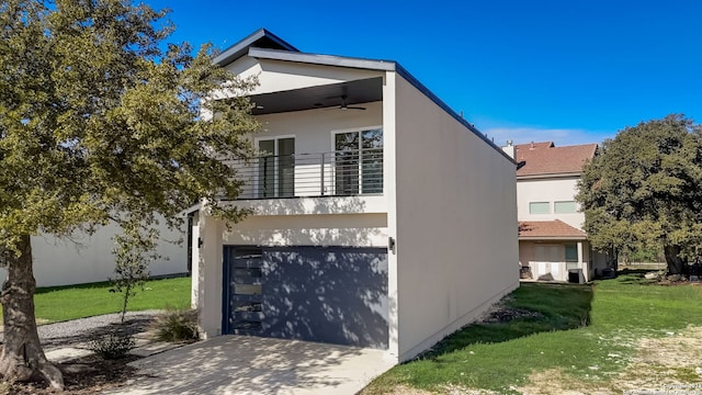 view of front facade featuring a garage, a front lawn, and ceiling fan