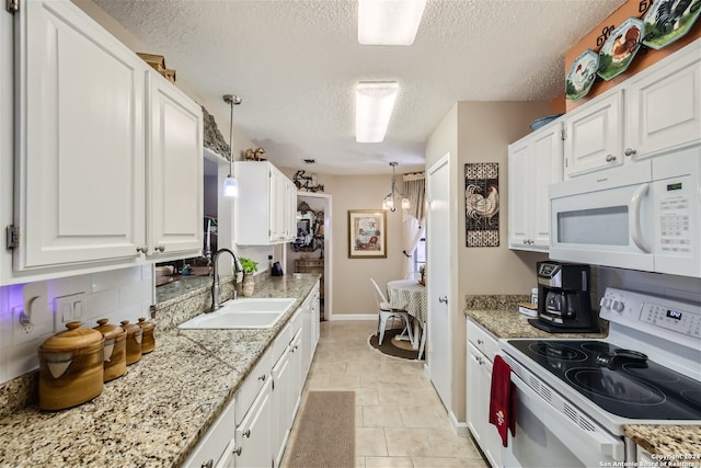 kitchen with white appliances, white cabinetry, and a sink