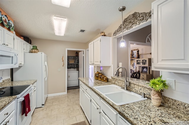 kitchen featuring white appliances, washer / clothes dryer, white cabinetry, pendant lighting, and a sink