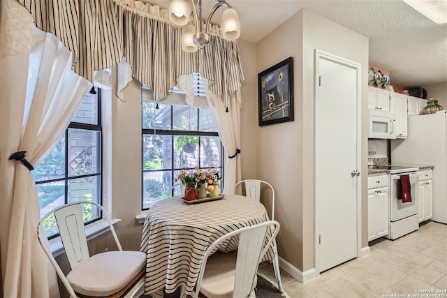 dining area featuring baseboards, a chandelier, and a textured ceiling