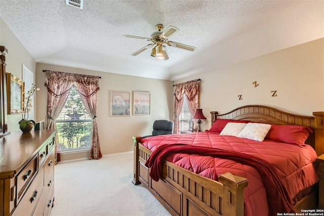 bedroom featuring light colored carpet, visible vents, baseboards, and a textured ceiling