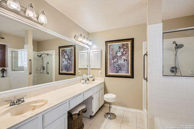 bathroom featuring a textured ceiling, double vanity, tile patterned flooring, and a sink