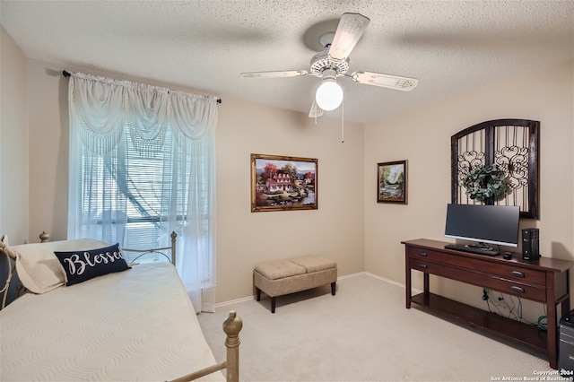 bedroom featuring light colored carpet, a textured ceiling, and baseboards