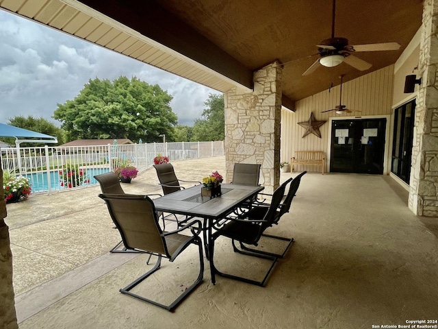 view of patio with a fenced in pool, outdoor dining area, ceiling fan, and fence