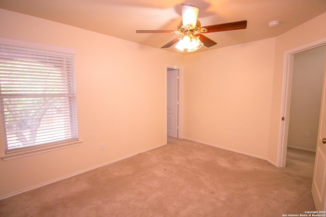 carpeted spare room with ceiling fan