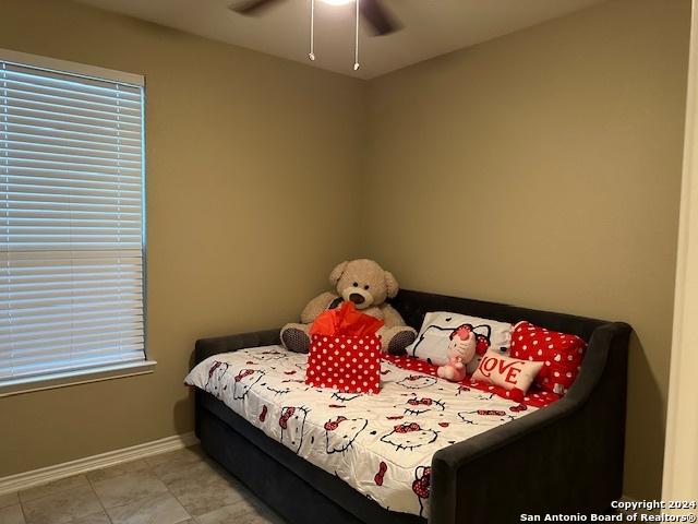 bedroom with light tile patterned floors and ceiling fan