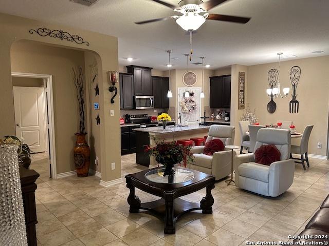 living room with sink and ceiling fan with notable chandelier